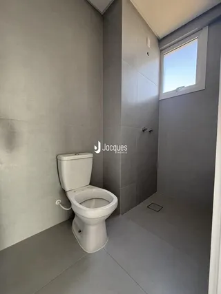 Foto interna de um banheiro moderno com revestimento de cerâmica cinza.