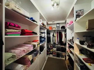 Hall com estantes e roupas organizadas em um ambiente interno.