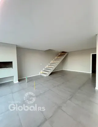 Ambiente interno de uma sala com escadaria em um imóvel.