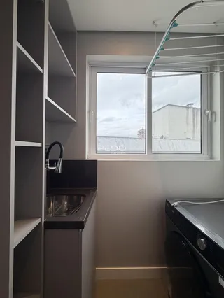 Vista interna de uma cozinha com janela para o exterior.