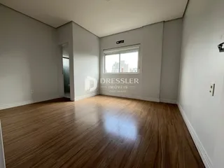Sala de estar com piso de madeira clara e paredes brancas.