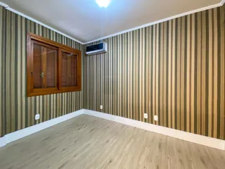 Esta é uma sala com paredes listradas e piso de madeira clara.