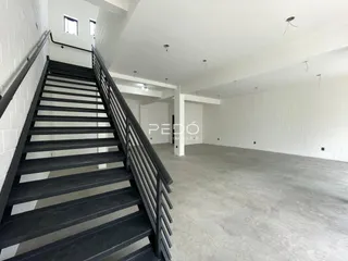Vista de uma escadaria e área interna de uma residência.