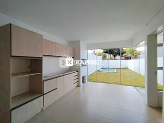 Ambiente interno com armários de madeira e vista para um jardim com piscina.