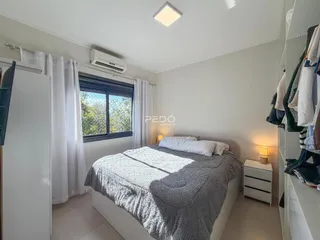 Quarto com cama, armários e ar-condicionado em um imóvel no Brasil.