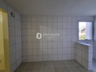 Parede interna com revestimento cerâmico e piso claro de uma residência.