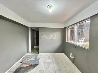 Foto de um corredor interno com paredes cinzas e piso de cerâmica.