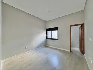 Foto de um ambiente interno com paredes claras e piso de madeira clara.