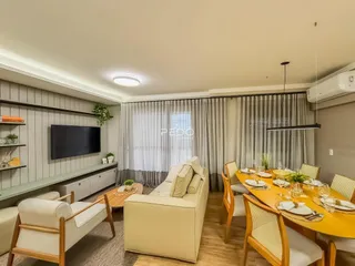 Sala de estar e jantar com sofá e mesa de madeira em um apartamento.