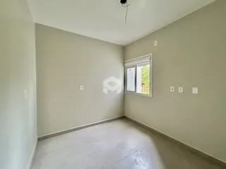 Ambiente interno de uma sala vazia com paredes claras e piso de cerâmica.