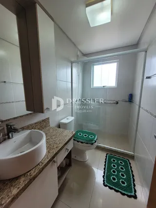 Foto de um banheiro interno com azulejos brancos e louças sanitárias.