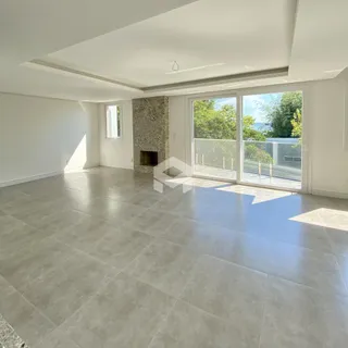 Sala de estar com piso de grande formato e vista para o exterior.
