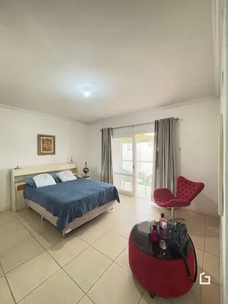 Quarto com cama e piso de cerâmica.