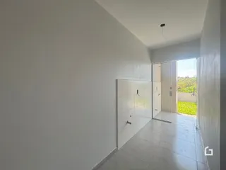 Corredor com paredes brancas e piso de cerâmica.