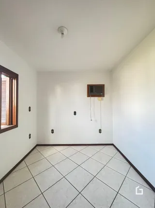 Foto de um cômodo interno com piso de cerâmica e paredes brancas.