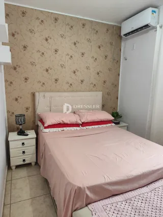 Quarto com cama e cabeceira em parede com papel de parede.