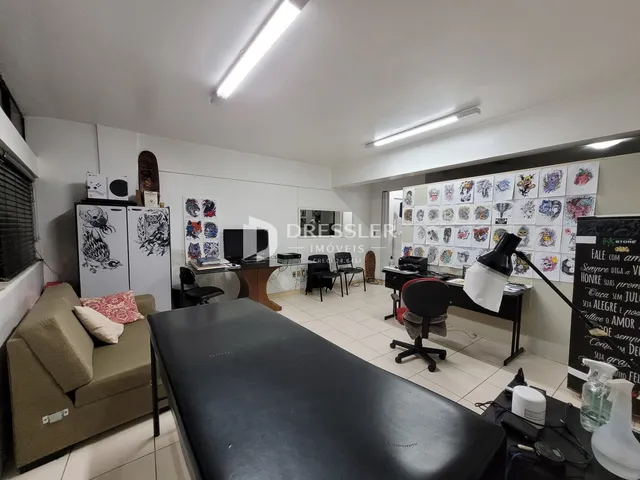 Ambiente interno de uma sala de estar com sofá e área de trabalho.