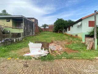 Vista externa de um terreno com grama seca e cascalho no primeiro plano.