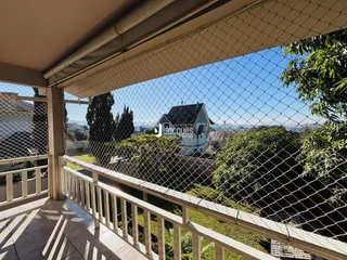 Vista da varanda com paisagem verde ao fundo.