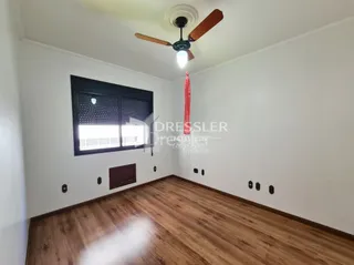 Foto de um cômodo interno com piso de madeira e paredes brancas.