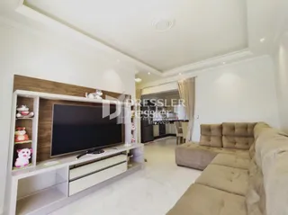 Sala de estar com sofá e painel de madeira na decoração.