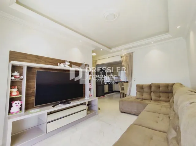 Sala de estar com sofá e painel de madeira na decoração.