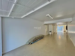 Corredor interno com paredes brancas e piso de cerâmica.