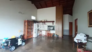 Vista interna de uma sala com piso de cerâmica e teto de madeira.