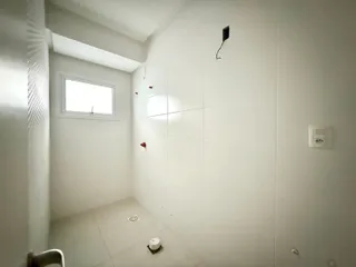 Foto de um corredor interno com paredes brancas e piso de cerâmica.