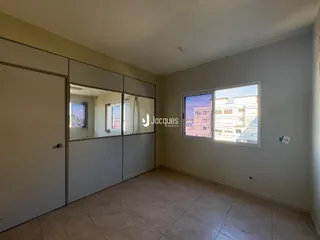 Interior de uma sala com piso de cerâmica e janela.