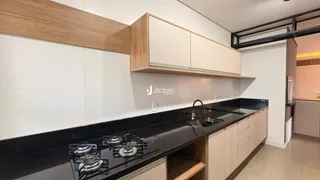 Uma cozinha moderna com armários de madeira e bancadas escuras.