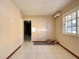 Uma sala de estar clara com piso de cerâmica e janela.