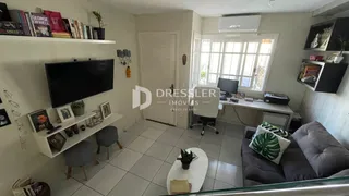 Sala de estar com televisão e estantes em um imóvel no Brasil.