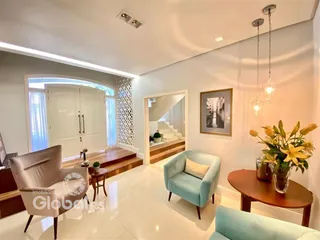 Sala de estar iluminada com móveis claros e paredes brancas.