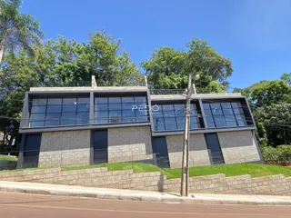 Fachada moderna de um imóvel em Lajeado, Brasil, com grandes janelas e paisagismo.