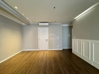 Sala de estar com piso de madeira e paredes brancas.