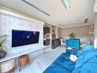 Sala de estar moderna com sofá azul e televisão em um apartamento no Brasil.