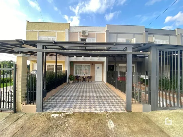 Fachada de uma residência em Lajeado, Brasil com portão de ferro.