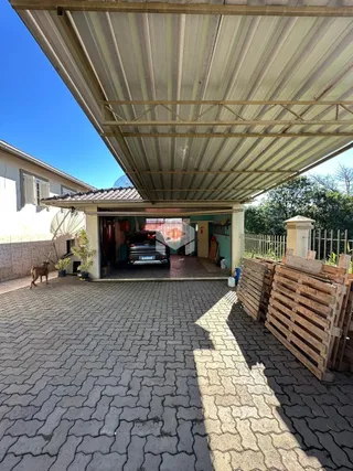 Vista da fachada de uma residência em Lajeado, Brasil com área externa pavimentada.