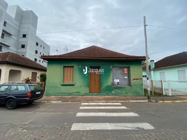 Fachada de uma casa verde com telhado de telhas vermelhas em Lajeado, Brasil.