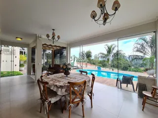 Sala de jantar com vista para a área externa e piscina.