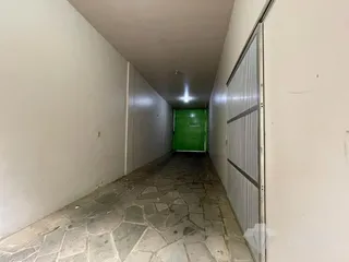 Corredor interno de uma residência com piso de pedra.