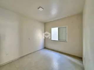 Hall de entrada com piso claro e paredes brancas.
