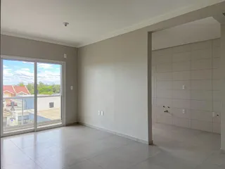 Sala de estar clara com porta de vidro que oferece vista para o exterior.