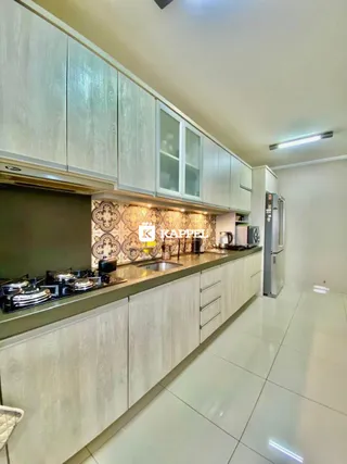 Cozinha moderna com armários superiores e inferiores e bancadas claras.