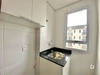 Banheiro com revestimento branco e bancada escura.