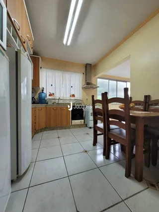 Foto da cozinha e sala de jantar com piso de cerâmica e móveis de madeira.