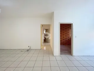 Corredor com piso cerâmico claro que leva a outra sala.