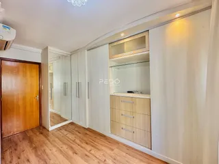 Quarto com piso de madeira e armários embutidos.
