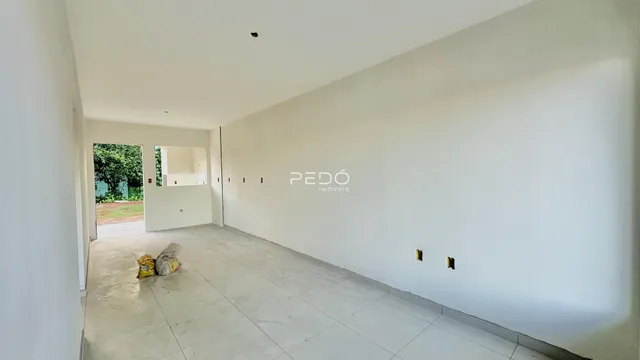 Corredor interno de uma residência com paredes brancas e piso claro.